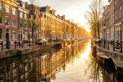 Maisons étroites au bord d'un canal d'Amsterdam au coucher du soleil